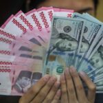 petugas-menjunjukkan-uang-pecahan-dolar-as-dan-rupiah-di-dolarindo-money-changer-jakarta-selasa-842025-1744086432570_169