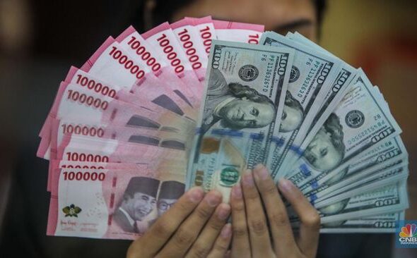 petugas-menjunjukkan-uang-pecahan-dolar-as-dan-rupiah-di-dolarindo-money-changer-jakarta-selasa-842025-1744086432570_169